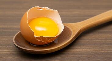 A wooden spoon with an egg on it photo