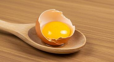 A wooden spoon with an egg in it photo