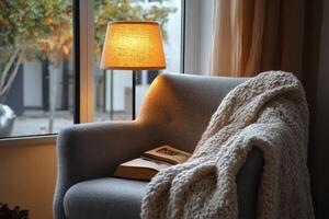 Cozy Reading Nook with Soft Chair and Wool Throw A cozy reading nook featuring a soft armchair, a wool throw blanket, and a simple lamp casting warm light, creating a perfect spot for relaxation. photo