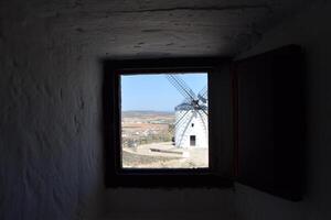 Scenic view of spanish windmill through window frame. Consuegra. La Mancha. Spain. photo