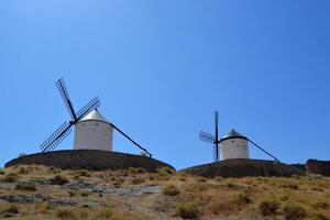 Scenic view of traditional spanish windmills in rural landscape on a sunny day. Consuegra. La Mancha. Spain photo
