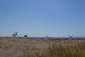 Scenic view of traditional windmills in the spanish countryside on a clear day. Campo de Criptana. La Mancha. Spain photo