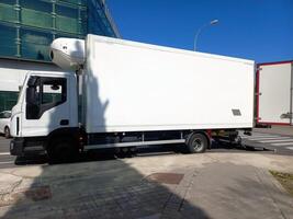 Efficient urban delivery with a white refrigerated truck on a city street. Delivery template photo