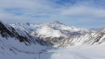 Drone footage capturing skiers gliding down powdery slopes near Kobi, part of the Gudauri Ski Resort in Georgia, with panoramic views of the Greater Caucasus mountains video
