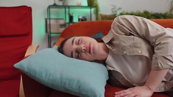 Tired young woman girl lying down in bed taking a rest at home, napping, falling asleep on couch video