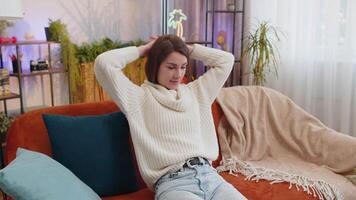 Tired lazy woman enjoy relaxing on home sofa resting napping after hard working day, closed her eyes video