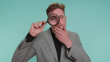Investigator researcher man with magnifying glass near face, looking into camera with big zoom eye video