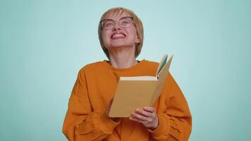 Young woman in glasses reading funny interesting fairytale story book, laughing, leisure hobby video
