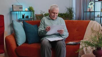 Happy grandfather man work with documents from home, analyzing information prepare financial report video