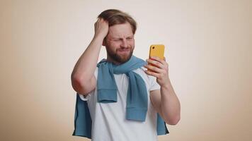 Sad man use smartphone typing browsing loses becoming surprised sudden lottery result bad fortune video