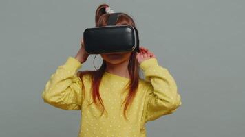 Child kid girl using headset helmet app to play simulation game, watching virtual reality 3D video