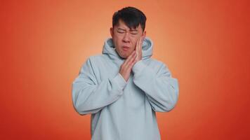 Man touching cheek suffering from toothache cavities or gingivitis waiting for dentist appointment video