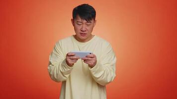 Worried funny addicted tourist guy enthusiastically playing drive racing game on mobile phone video