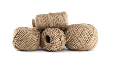 Close-up shot of several balls of rustic twine on a clean, bright white background. photo