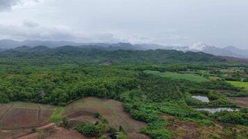 Beautiful aerial view of rolling hills under dramatic cloudy skies after rainfall. Tranquil rural landscape perfect for cinematic use. video
