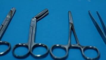 Set of surgical instrument in a row with blue background. video