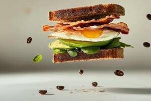 A sandwich with bacon, avocado and egg flying in the air photo