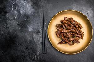 Asian food Teriyaki beef meat on a plate on black background. top view photo