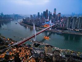 Chongqing, China-APR 03, 2025-a twilight Cityscape of the famous downtown shopping complex and CBD with illuminated bridge and highrise building in Chongqing, China photo