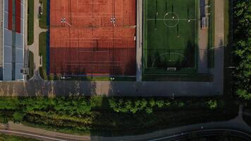 Top view of Sports grounds with people playing on them in Minsk.Football field and tennis courts in the city of Minsk, district of silverfish.Belarus video