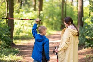 A woman and a boy are walking through the woods photo