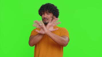 Afraid indian man closing eyes with hand showing stop gesture, confused shy scared to watch, awful video