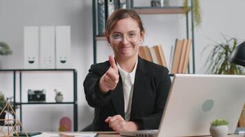 Happy business woman looking approvingly at camera showing thumbs up, like positive sign, good news video