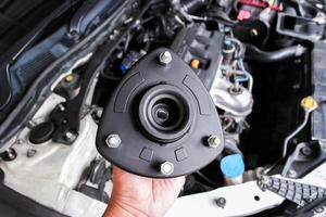 Shock Absorber Strut Mount, Top strut mount of suspension shock absorber strut in mechanic hand. photo