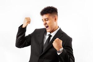 Portrait of a handsome man wearing business suite over white background very happy and excited doing winner gesture with arms raised, smiling and screaming for success. Celebration photo