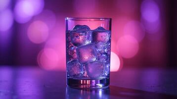 A glass filled with ice is illuminated by a soft, glowing purple light, creating a serene and captivating ambiance. photo