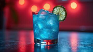A vibrant blue cocktail, garnished with a slice of lime, glows against a blurred, illuminated backdrop. photo