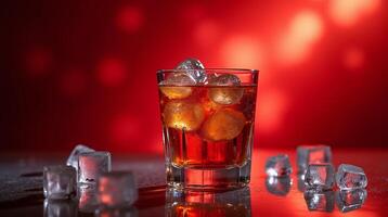 A transparent glass filled with ice cubes containing a reddish-brown liquid with a deep red illuminated background with scattered ice cubes. photo