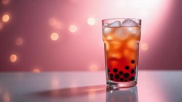 A tall glass filled with a vibrant red beverage, featuring ice cubes and dark spherical objects, sits against a softly lit, bokeh background. photo