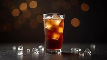 A tall glass filled with refreshing iced tea, garnished with ice cubes, against a dimly lit, bokeh-filled backdrop. photo