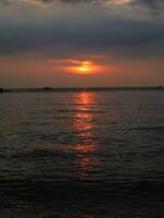 Panoramic sunset view at a luxury beach in the tropics, Serene sunset over calm ocean, photo