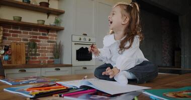 A Creative Child is Drawing Enthusiastically in a Bright and Colorful Room Filled with Light video
