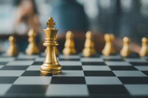 Close-up of golden chess pieces on a chessboard, highlighting the king in a strategic game setting. photo