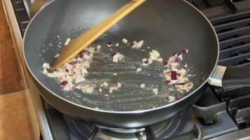 A frying pan with chopped onions sizzling on a stove, highlighting cooking, home kitchen, and culinary techniques video