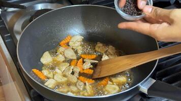 A person prepares a savory dish with vegetables and spices in a pan, highlighting cooking, gastronomy, and culinary arts video