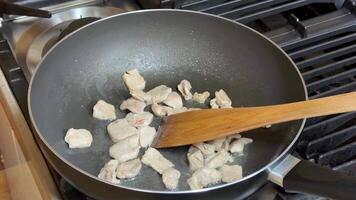 Cooking chicken pieces in a non stick pan on a gas stove, highlighting home cooking, culinary skills, and kitchenware video