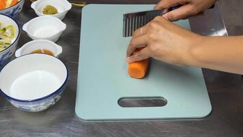 A person slices a carrot on a cutting board, showcasing culinary skills, meal preparation, and kitchen utensils in a vibrant setting video