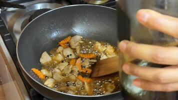 A pan filled with sizzling vegetables like carrots and eggplant, perfect for a stir fry or saute dish video