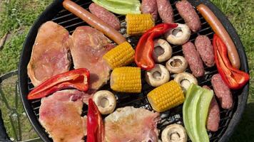 A vibrant barbecue grill with assorted meats, corn, and peppers, perfect for summer gatherings and cookouts video