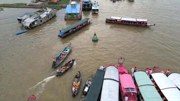 Aerial view of colorful boats at floating market in the Mekong Delta, Vietnam. Local vendors and tourists gather on the river, creating vibrant cultural scene. video