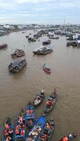 Aerial view of colorful boats at floating market in the Mekong Delta, Vietnam. Local vendors and tourists gather on the river, creating vibrant cultural scene. video