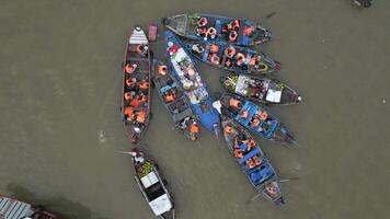 Top down view of colorful boats at floating market in the Mekong Delta, Vietnam. Local vendors and tourists gather on the river, creating vibrant cultural scene. video