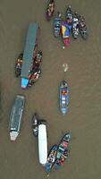 Top down view of colorful boats at floating market in the Mekong Delta, Vietnam. Local vendors and tourists gather on the river, creating vibrant cultural scene. video