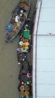 Top-down view of traditional floating market in Vietnam, with colorful boats filled with tropical fruits, vegetables, and local products. Real people, culture, and everyday life. video