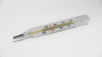 Close-up shot of clinical thermometer on white surface. photo