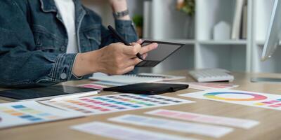 Design Workflow. Professional designer creating digital concepts with tablet and color samples. photo